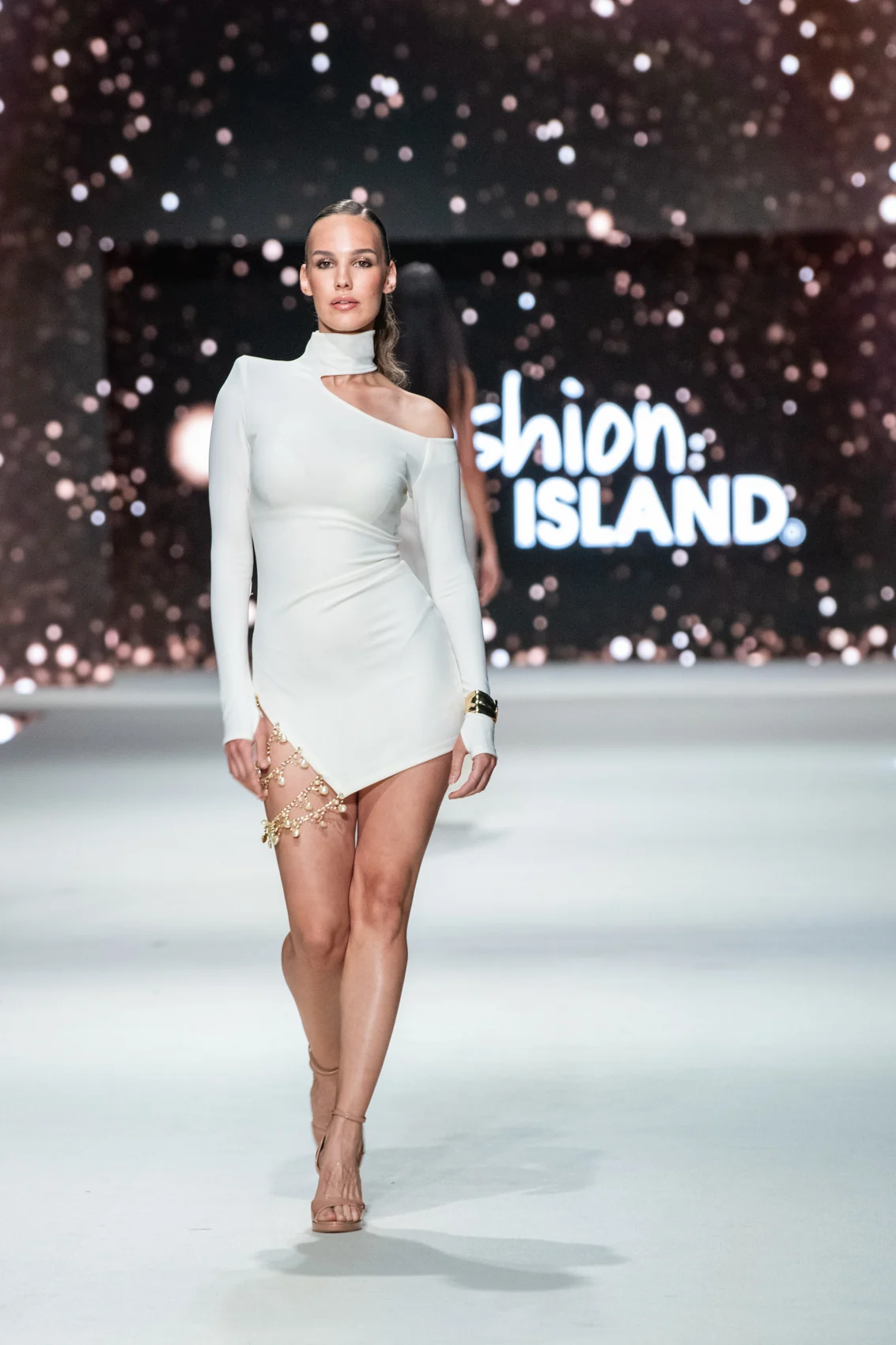 Modelka v bílém kompletu na přehlídkovém mole Fashion Island.